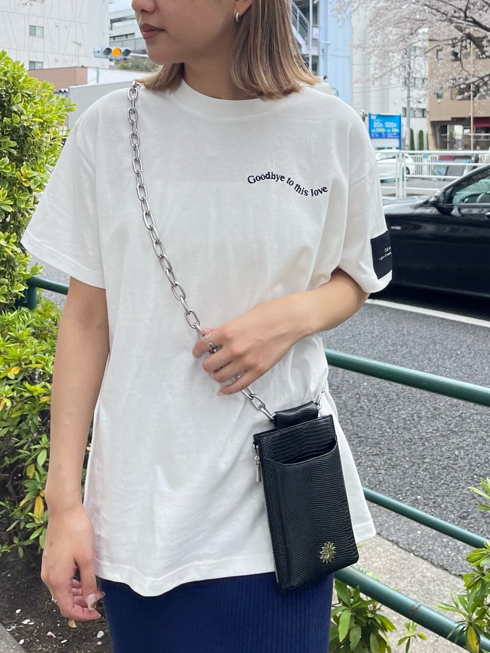 ブラック系のショルダーバッグ、ホワイト系のTシャツ/カットソー、ブルー系のスカートを着用したレディースの春コーディネートの8枚目の写真