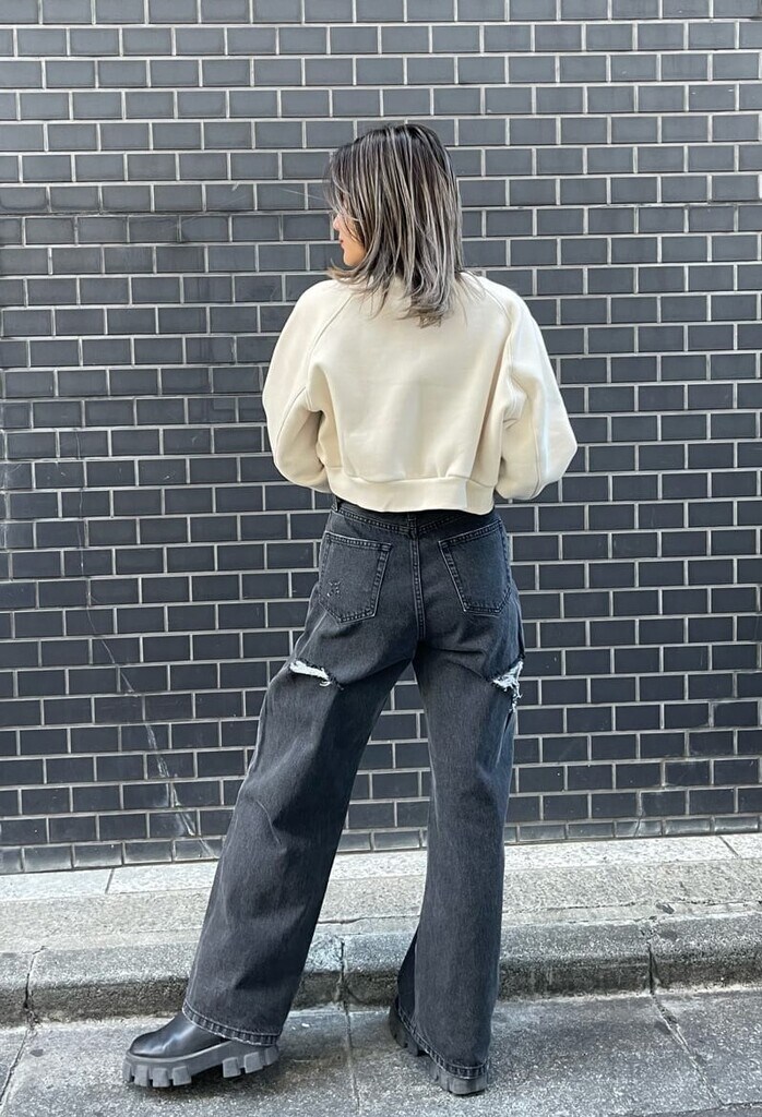 ブラック系のデニムパンツ、ブラック系のブーツ、ホワイト系のスウェットを着用したレディースの冬コーディネートの4枚目の写真