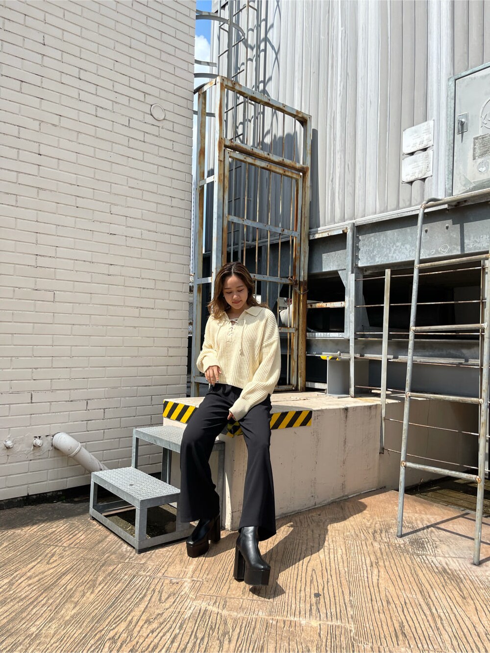 ブラック系のその他パンツ、ブラック系のブーツ、ホワイト系のニット/セーターを着用したレディースの秋コーディネートの4枚目の写真