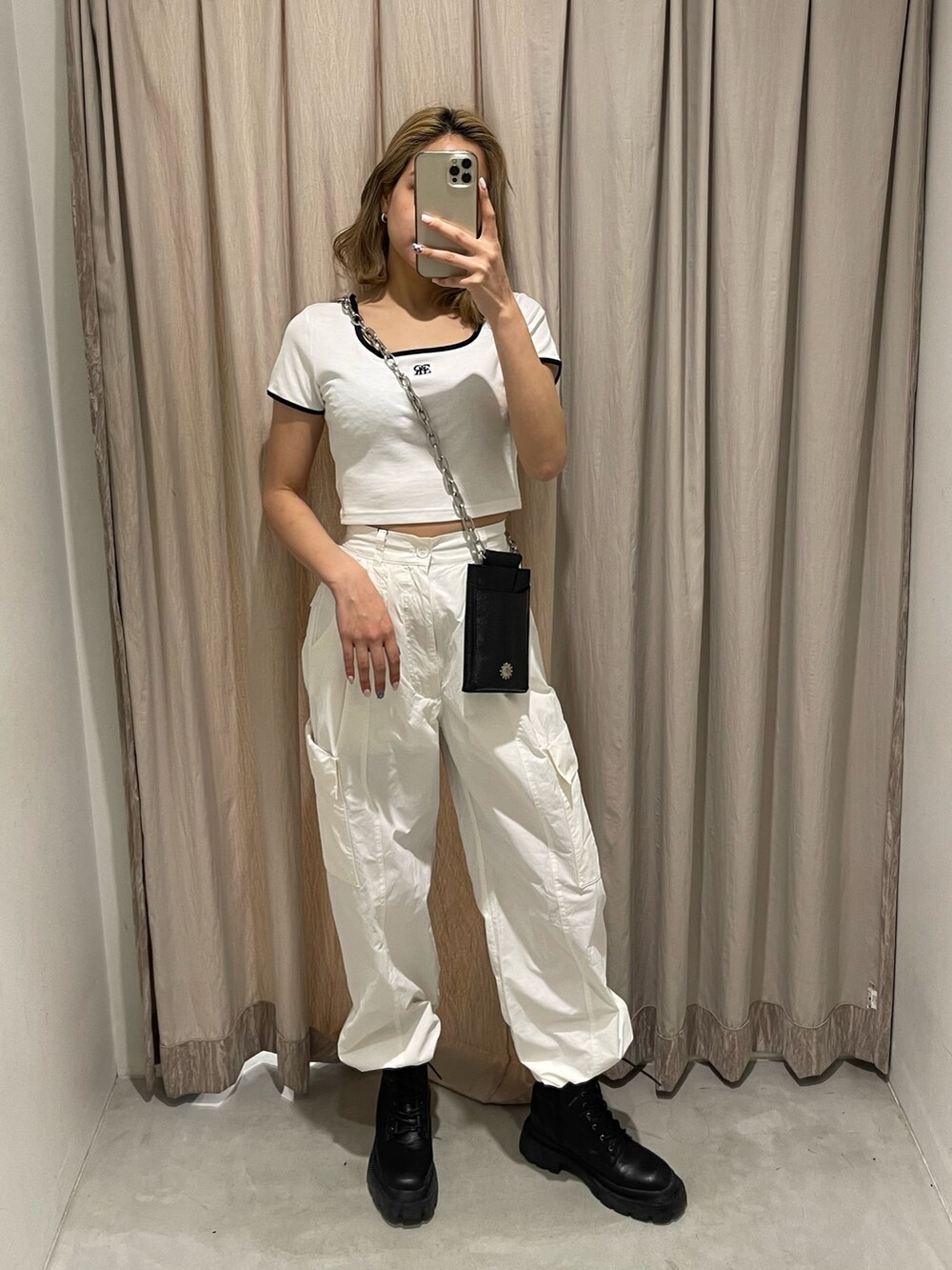 ホワイト系のカーゴパンツ、ブラック系のブーツ、ホワイト系のTシャツ/カットソーを着用したレディースの春コーディネートの2枚目の写真