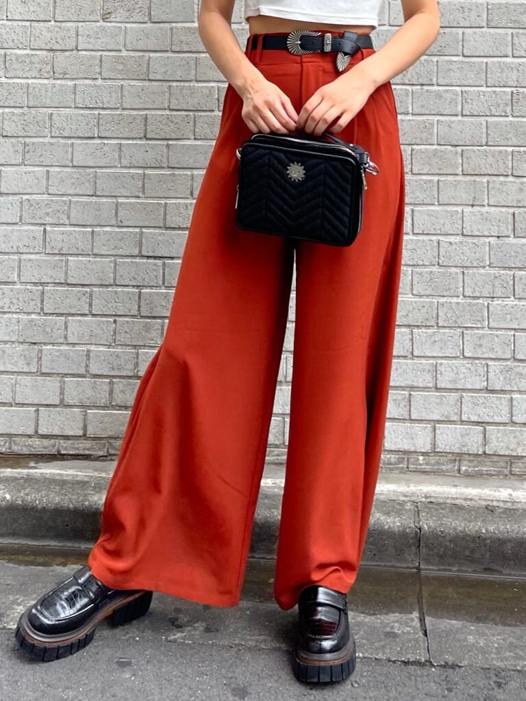 ブラック系のローファー、オレンジ系のその他パンツ、ブラック系のハンドバッグを着用したレディースの夏コーディネートの4枚目の写真