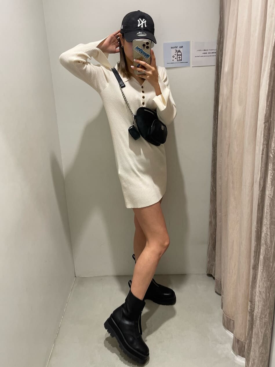 ブラック系のブーツ、ブラック系のボディバッグ/ウエストポーチ、ホワイト系のワンピースを着用したレディースの冬コーディネートの2枚目の写真