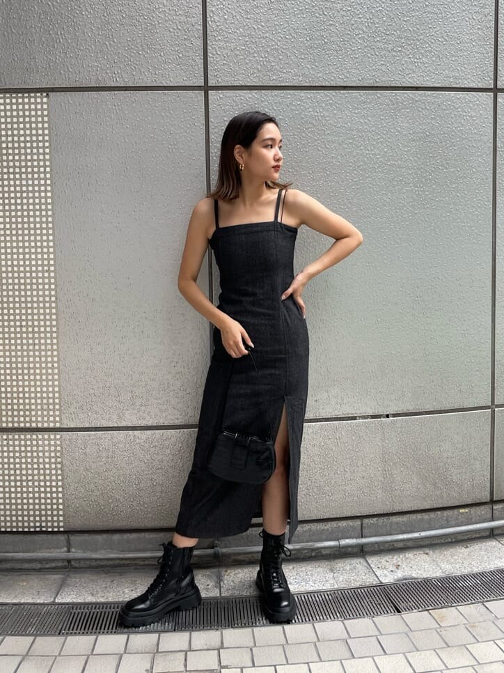 ブラック系のハンドバッグ、ブラック系のワンピース、ブラック系のブーツを着用したレディースの夏コーディネートの4枚目の写真