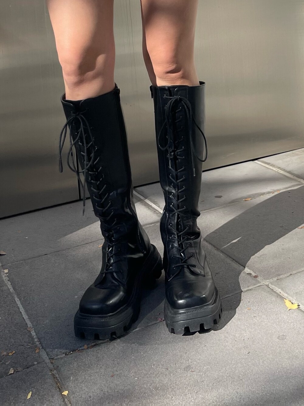 ブラック系のブーツ、ブラック系のワンピース、ホワイト系のショルダーバッグを着用したレディースの冬コーディネートの8枚目の写真