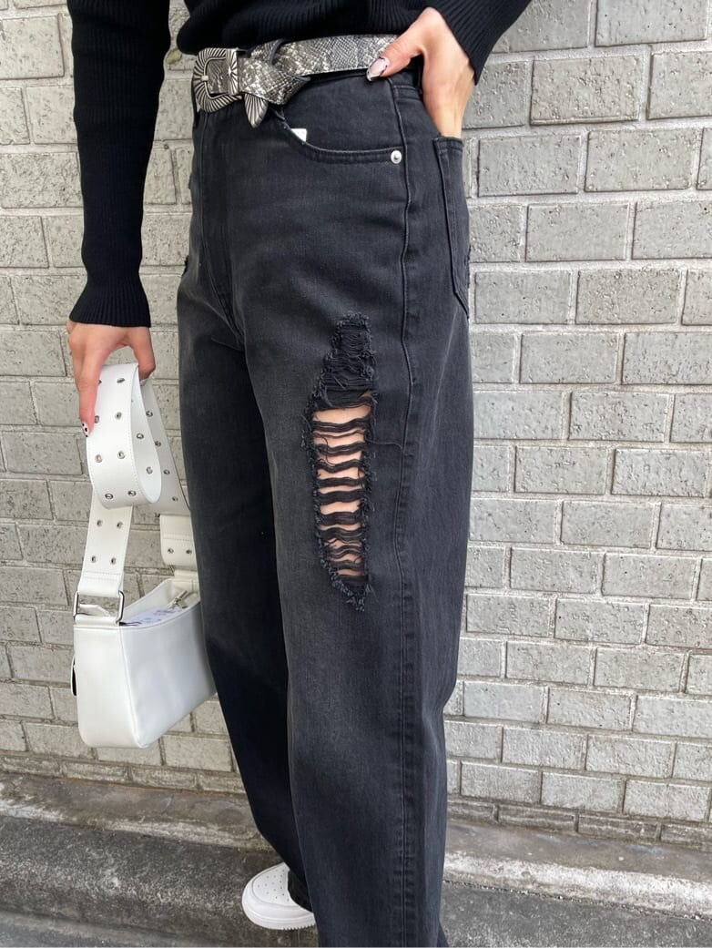 ブラック系のデニムパンツ、ブラック系のニット/セーター、ホワイト系のショルダーバッグを着用したレディースの冬コーディネートの6枚目の写真