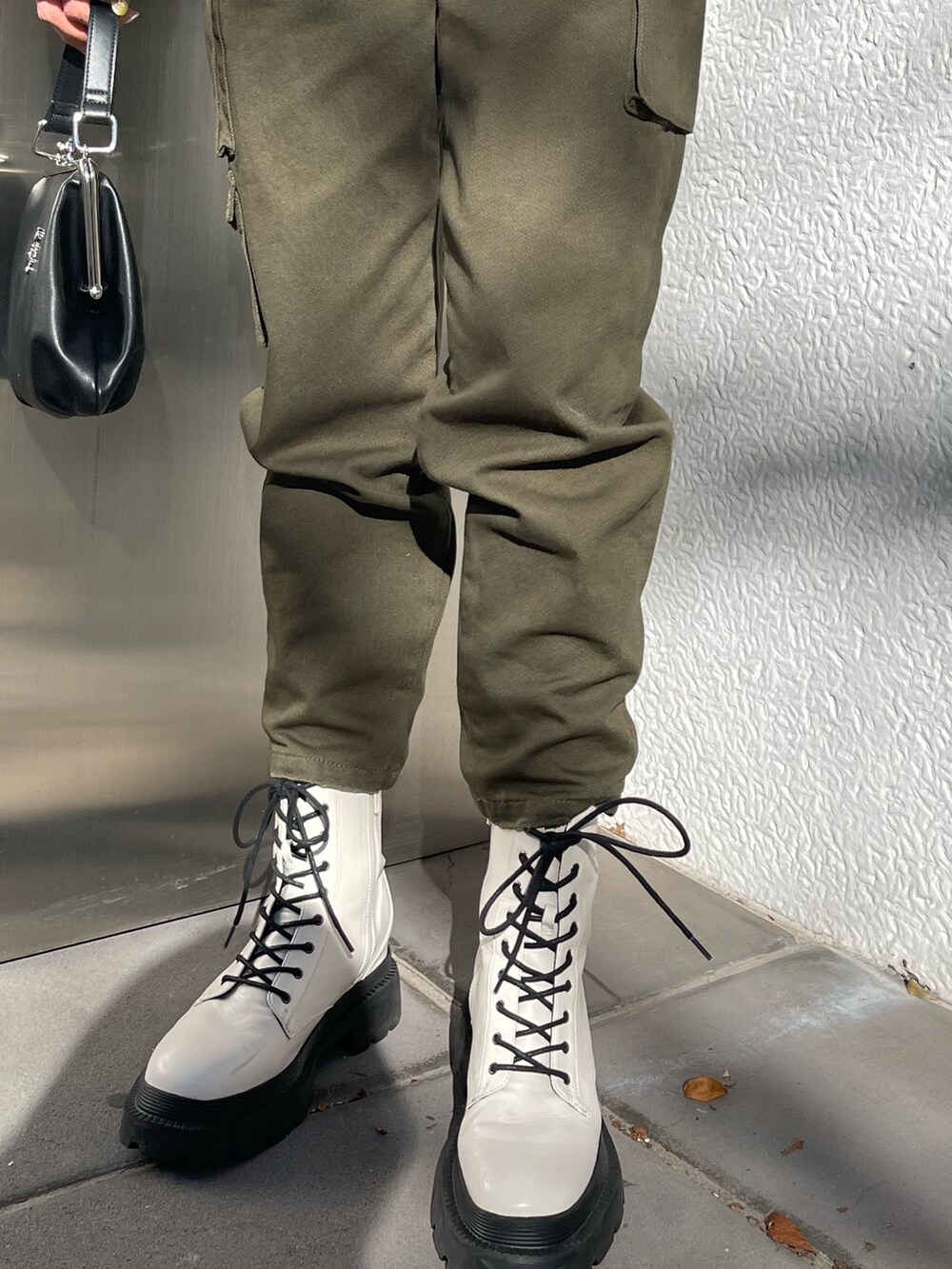 ブラック系のカーディガン/ボレロ、ブラック系のショルダーバッグ、ホワイト系のブーツを着用したレディースの冬コーディネートの7枚目の写真