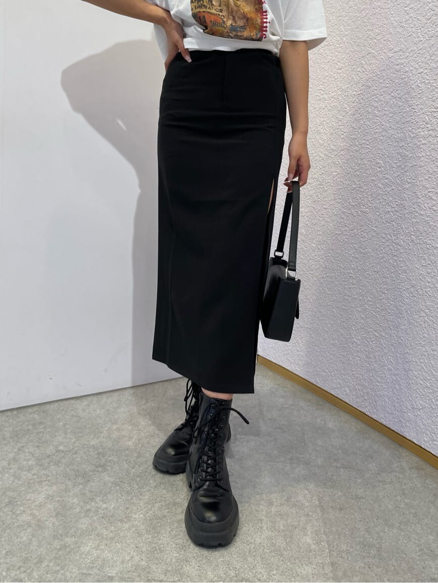 ブラック系のスカート、ブラック系のブーツ、ブラック系のショルダーバッグを着用したレディースの夏コーディネートの6枚目の写真