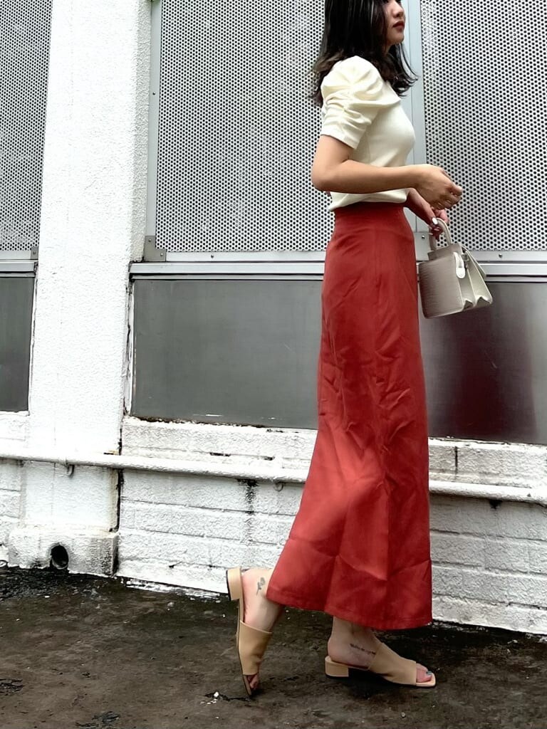 オレンジ系のスカート、ホワイト系のTシャツ/カットソーを着用したレディースの夏コーディネートの2枚目の写真