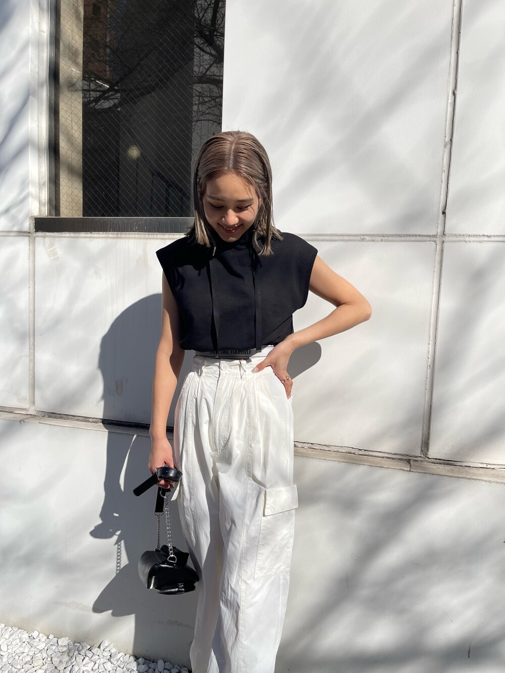 ホワイト系のカーゴパンツ、ブラック系のスウェット、ホワイト系のブーツを着用したレディースの春コーディネートの6枚目の写真