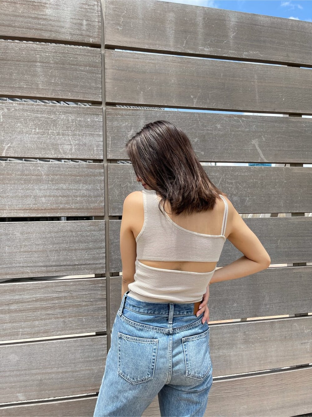 ブルー系のデニムパンツ、ブラウン系のサンダル、ホワイト系のTシャツ/カットソーを着用したレディースの夏コーディネートの4枚目の写真