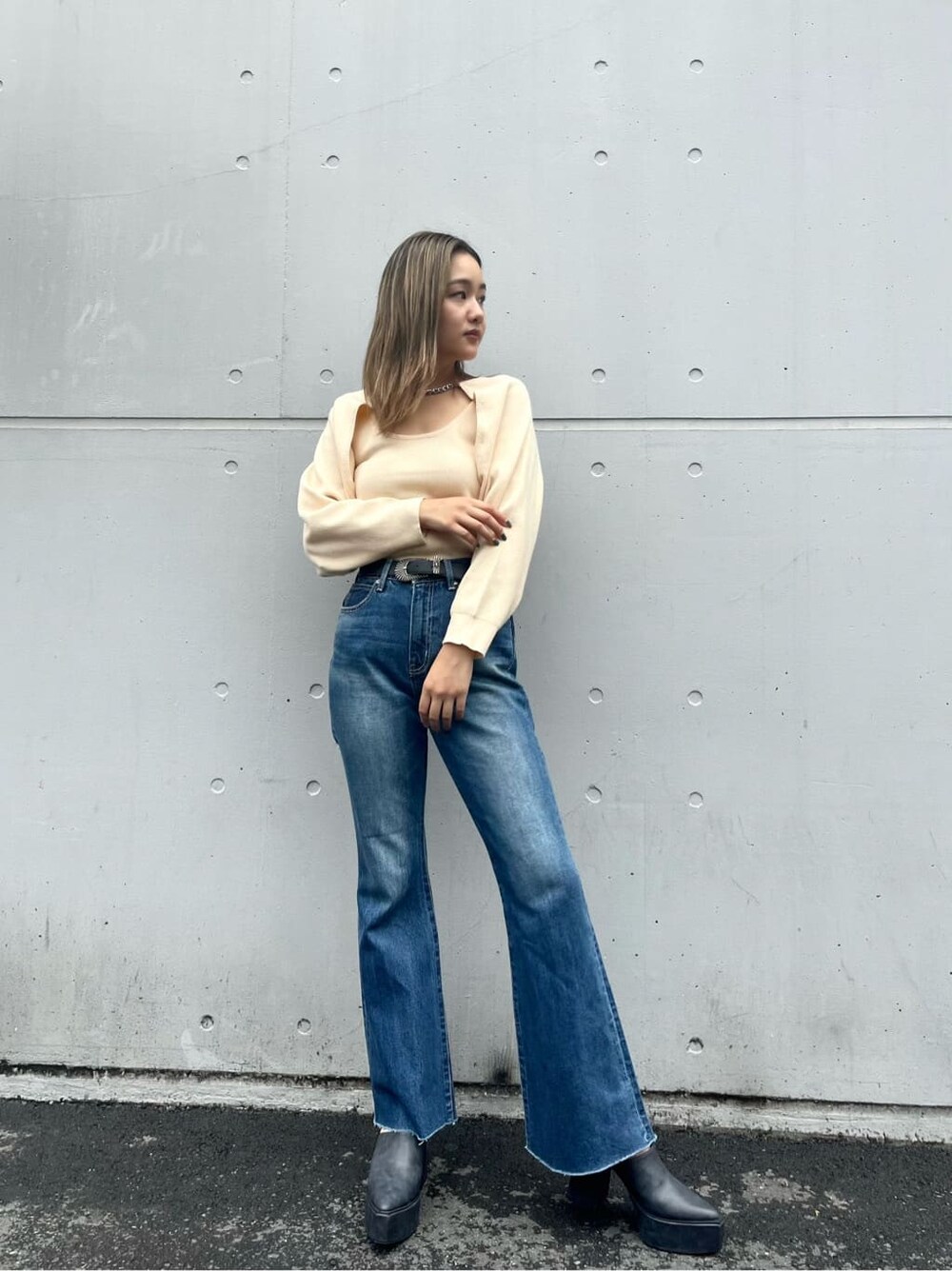 ブラック系のサンダル、ブルー系のデニムパンツ、ホワイト系のベルトを着用したレディースの秋コーディネートの2枚目の写真