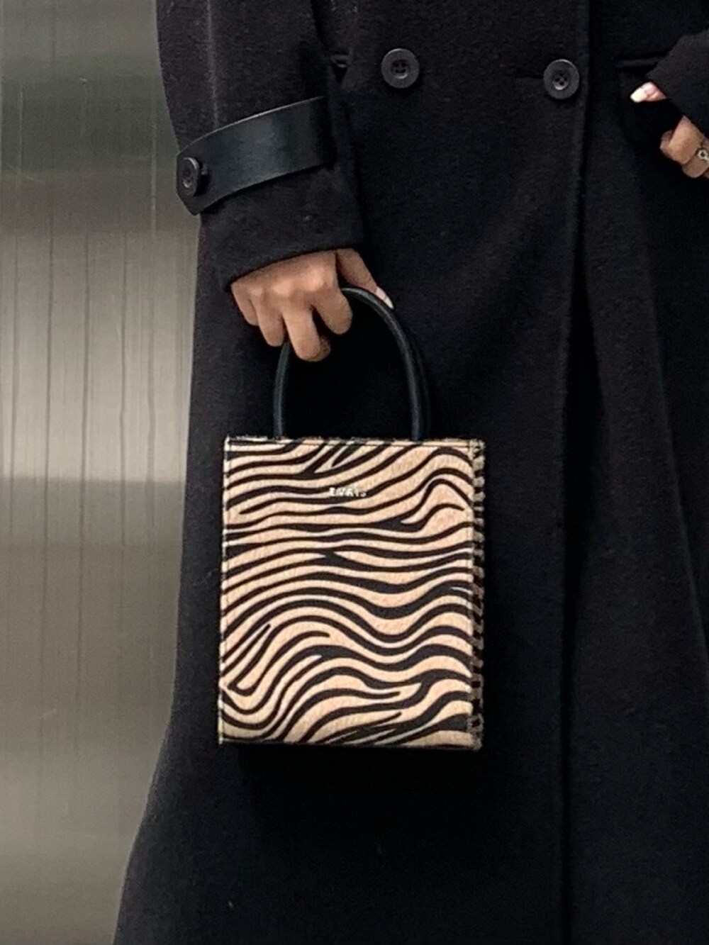 ブラック系のその他アウター、その他のショルダーバッグ、ブラック系のブーツを着用したレディースの秋コーディネートの6枚目の写真