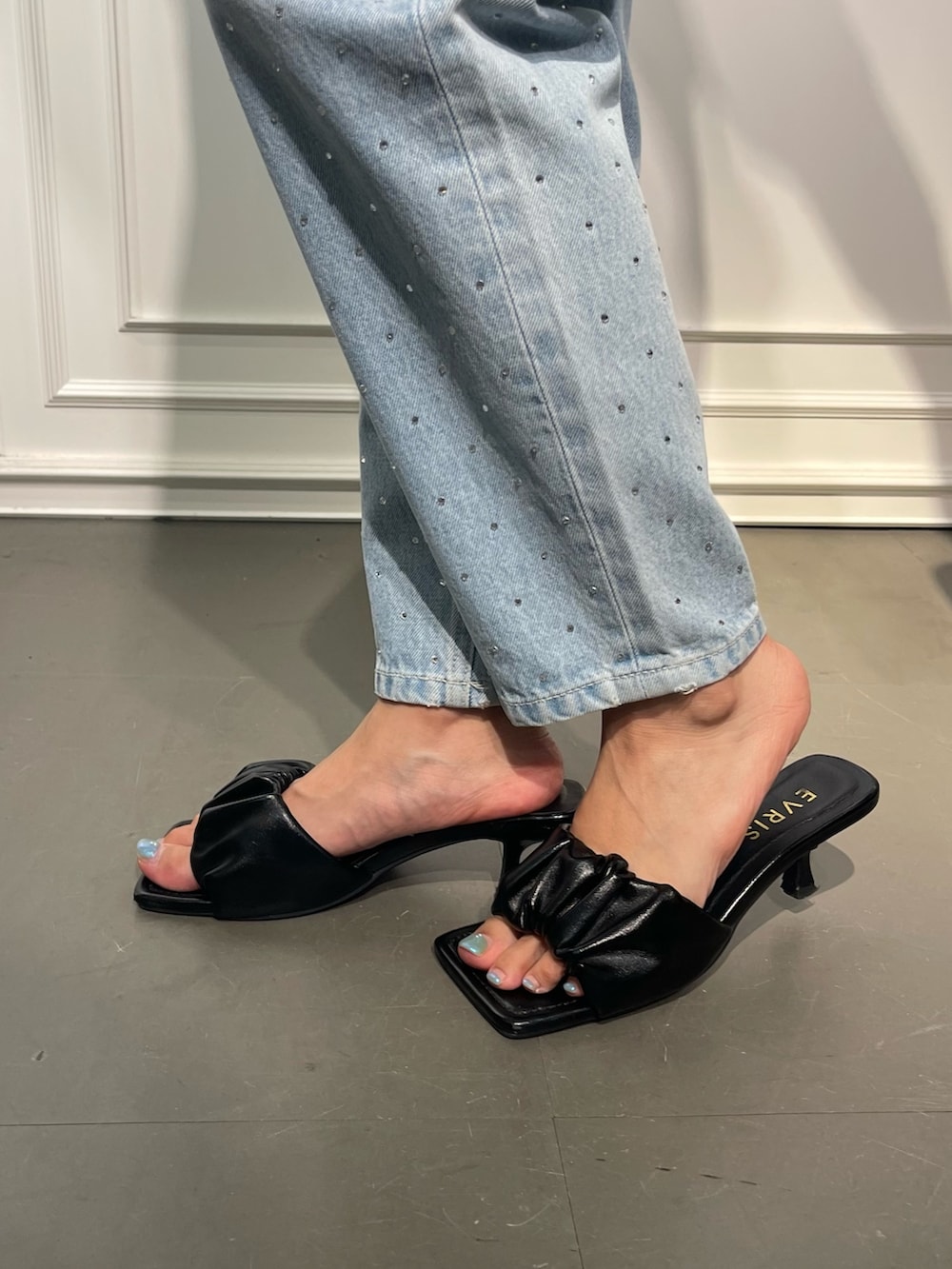 ブラック系のショルダーバッグ、ブルー系のデニムパンツ、ブラック系のサンダルを着用したレディースの夏コーディネートの8枚目の写真