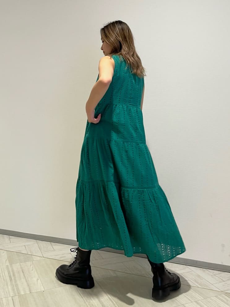 ブラック系のブーツ、グリーン系のワンピース、ベージュ系のショルダーバッグを着用したレディースの春コーディネートの5枚目の写真