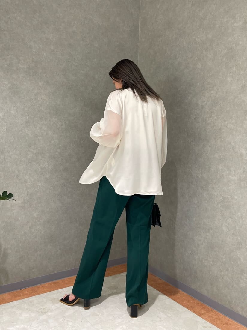 ホワイト系のタンクトップ、グリーン系のスラックス、ホワイト系のシャツ/ブラウスを着用したレディースの春コーディネートの3枚目の写真