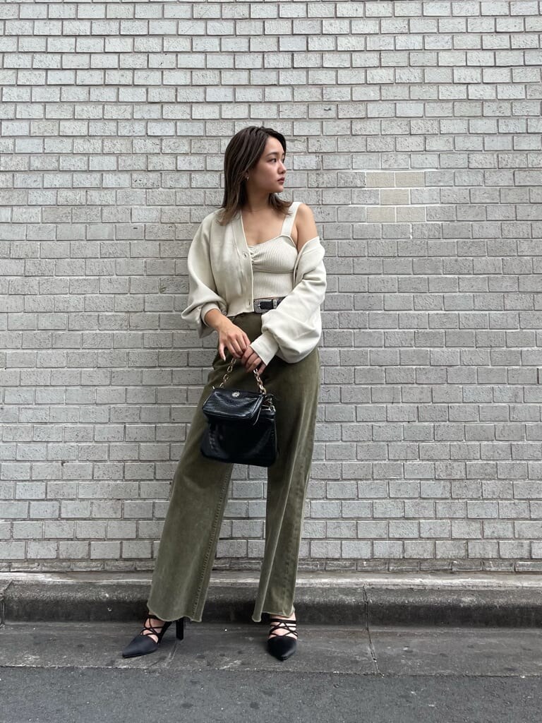 ブラック系のサンダル、ベージュ系のデニムパンツ、ブラック系のショルダーバッグを着用したレディースの秋コーディネートの3枚目の写真