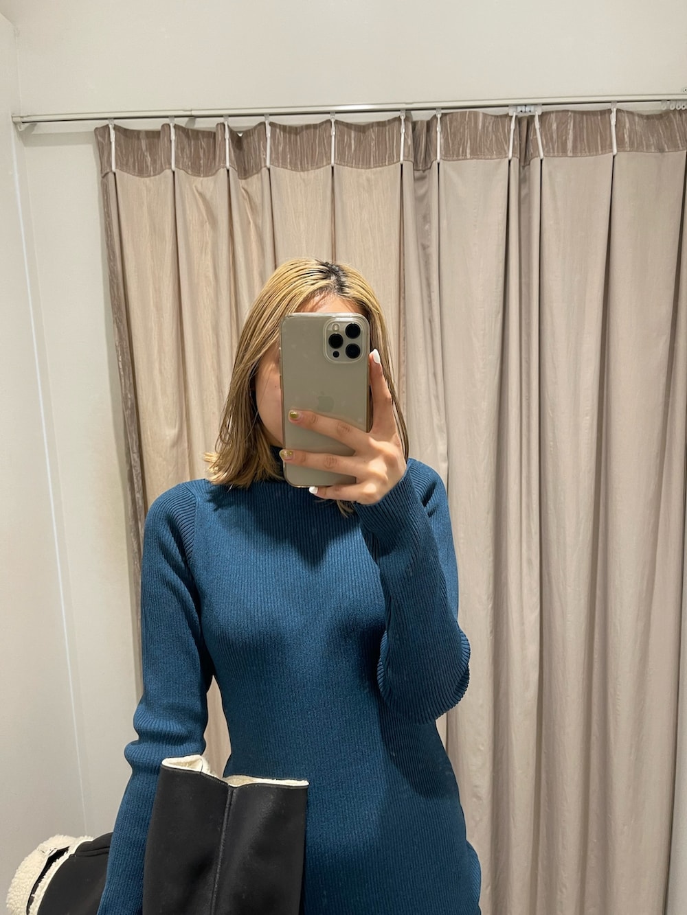 ブラック系のブルゾン、ブルー系のワンピース、ブラック系のブーツを着用したレディースの冬コーディネートの3枚目の写真