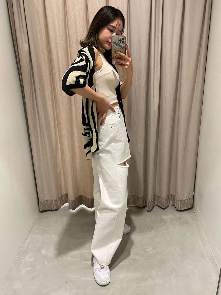 ホワイト系のキャミソール、ホワイト系のデニムパンツ、ブラック系のニット/セーターを着用したレディースの春コーディネートの3枚目の写真