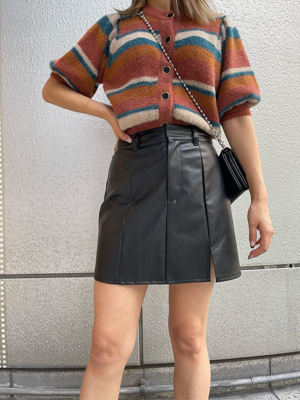 ブラック系のブーツ、ブラック系のショルダーバッグ、ブラック系のスカートを着用したレディースの秋コーディネートの4枚目の写真