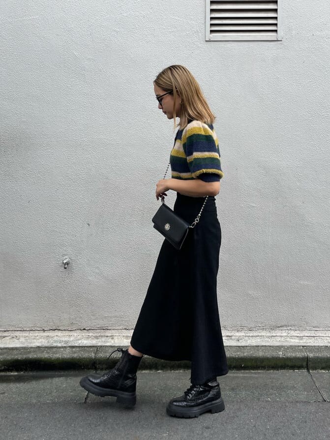 ブラック系のスカート、その他のブーツ、ブラック系のショルダーバッグを着用したレディースの秋コーディネートの5枚目の写真