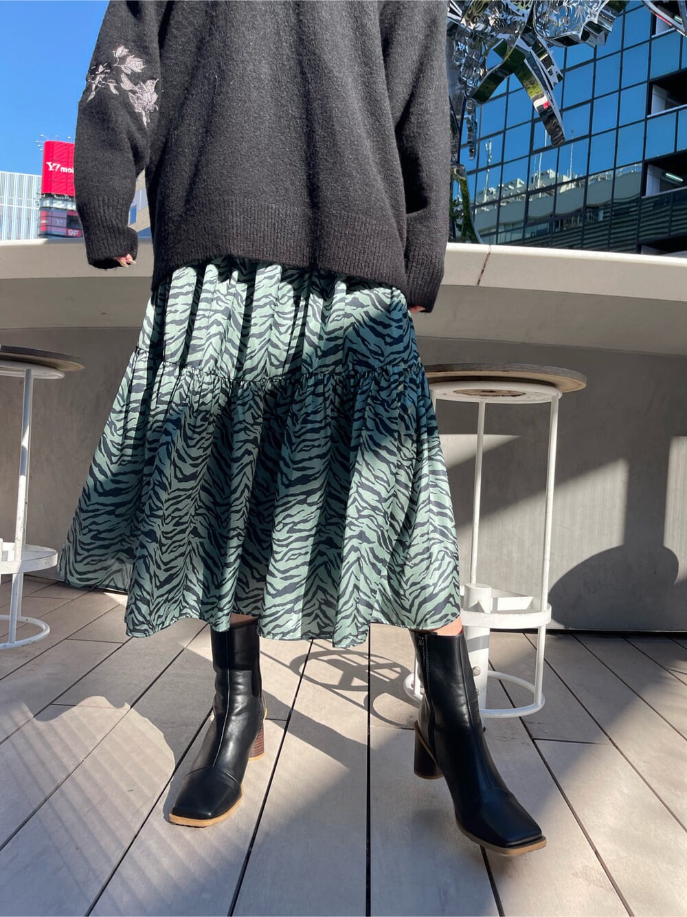 ブラック系のブーツ、グリーン系のワンピース、ブラック系のニット/セーターを着用したレディースの冬コーディネートの7枚目の写真