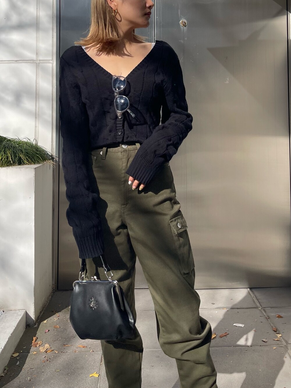 ブラック系のカーディガン/ボレロ、ブラック系のショルダーバッグ、ホワイト系のブーツを着用したレディースの冬コーディネートの4枚目の写真