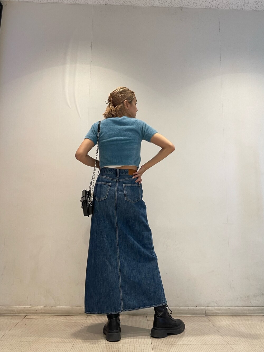 ブルー系のニット/セーター、ホワイト系のキャミソール、ブルー系のデニムスカートを着用したレディースの夏コーディネートの2枚目の写真