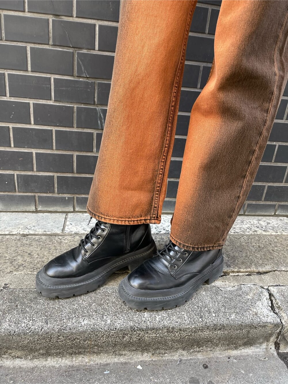 ブラック系のブルゾン、ブラック系のブーツ、ホワイト系のキャミソールを着用したレディースの春コーディネートの9枚目の写真