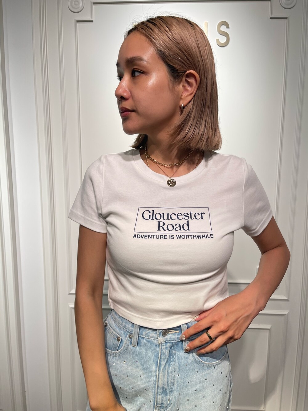 ブルー系のデニムパンツ、ブラック系のサンダル、ホワイト系のTシャツ/カットソーを着用したレディースの夏コーディネートの5枚目の写真