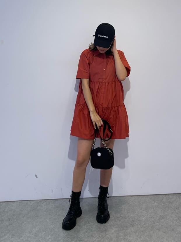 その他のブーツ、ブラック系のショルダーバッグ、オレンジ系のワンピースを着用したレディースの夏コーディネートの2枚目の写真