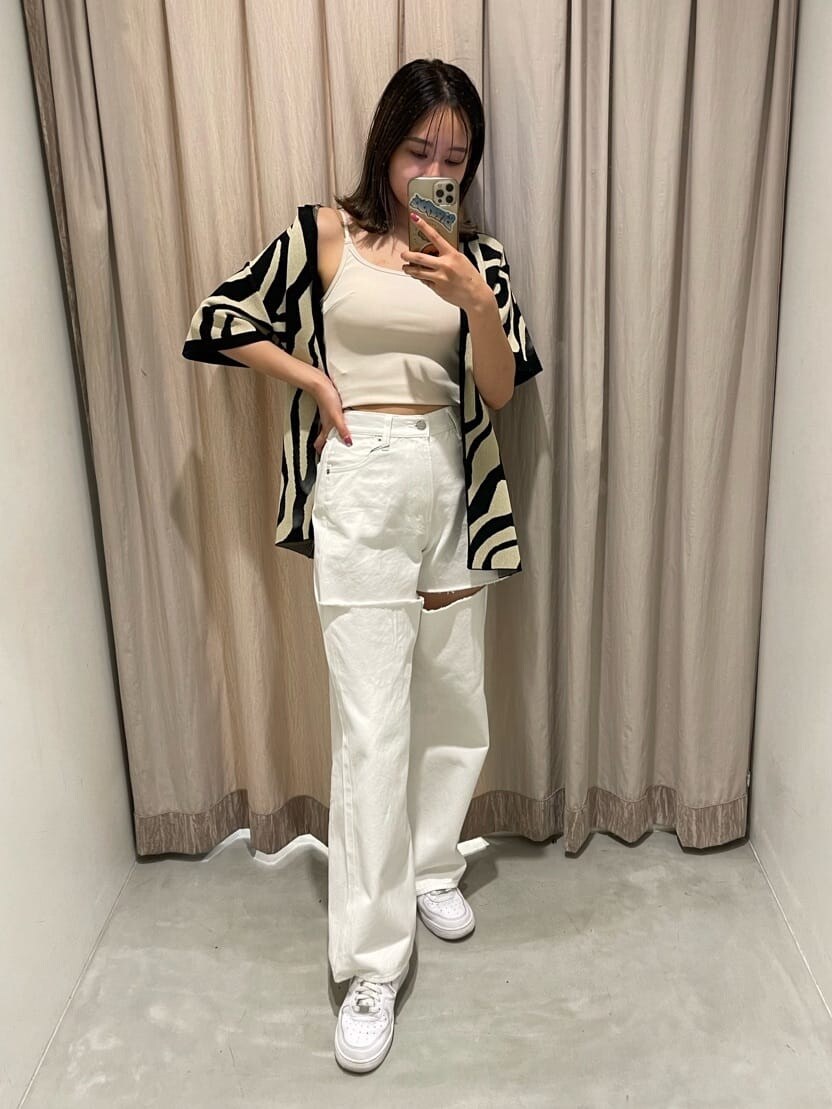 ホワイト系のキャミソール、ホワイト系のデニムパンツ、ブラック系のニット/セーターを着用したレディースの春コーディネートの2枚目の写真