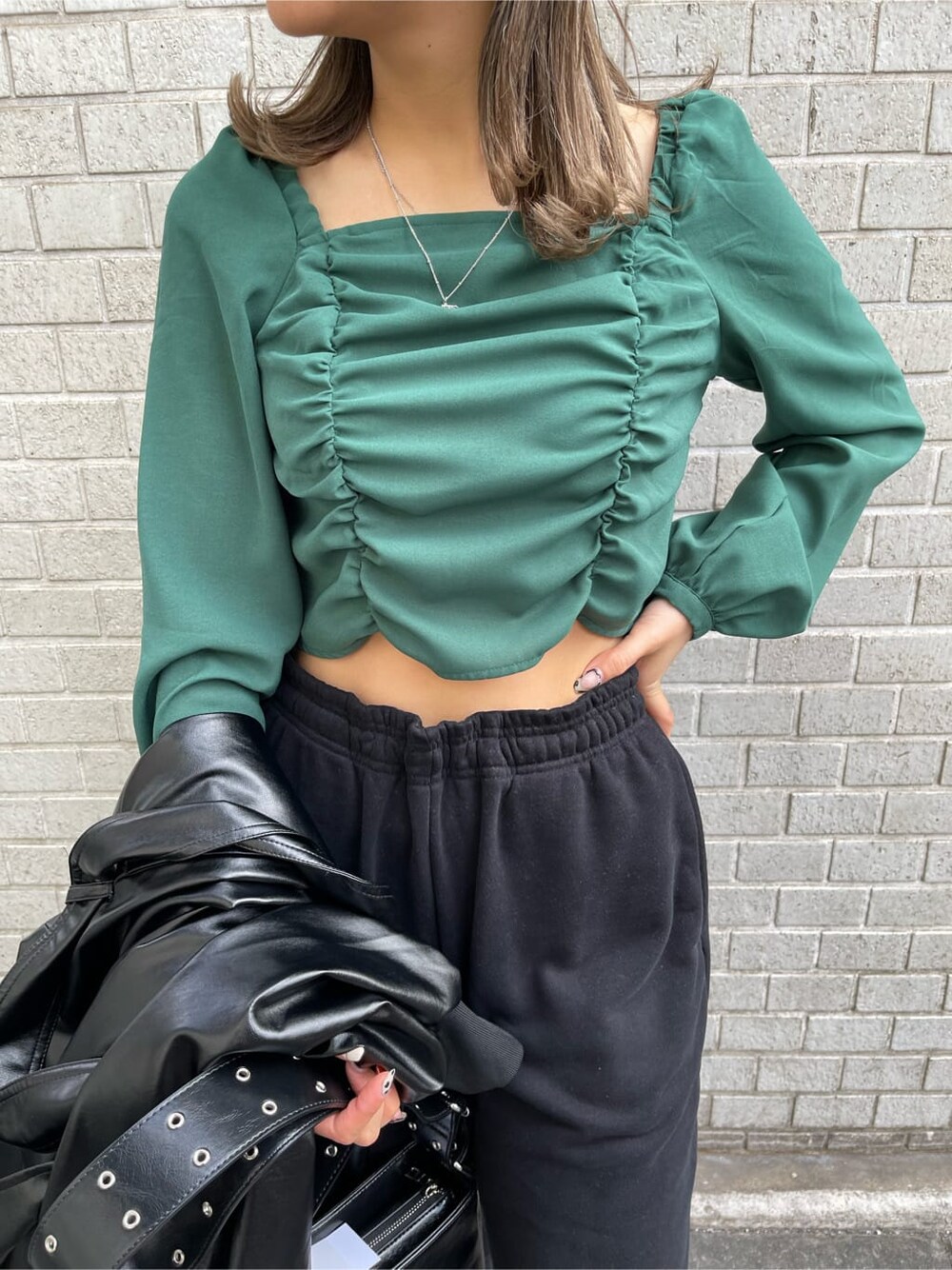 ブラック系のトレンチコート、グリーン系のシャツ/ブラウス、ブラック系のショルダーバッグを着用したレディースの冬コーディネートの4枚目の写真