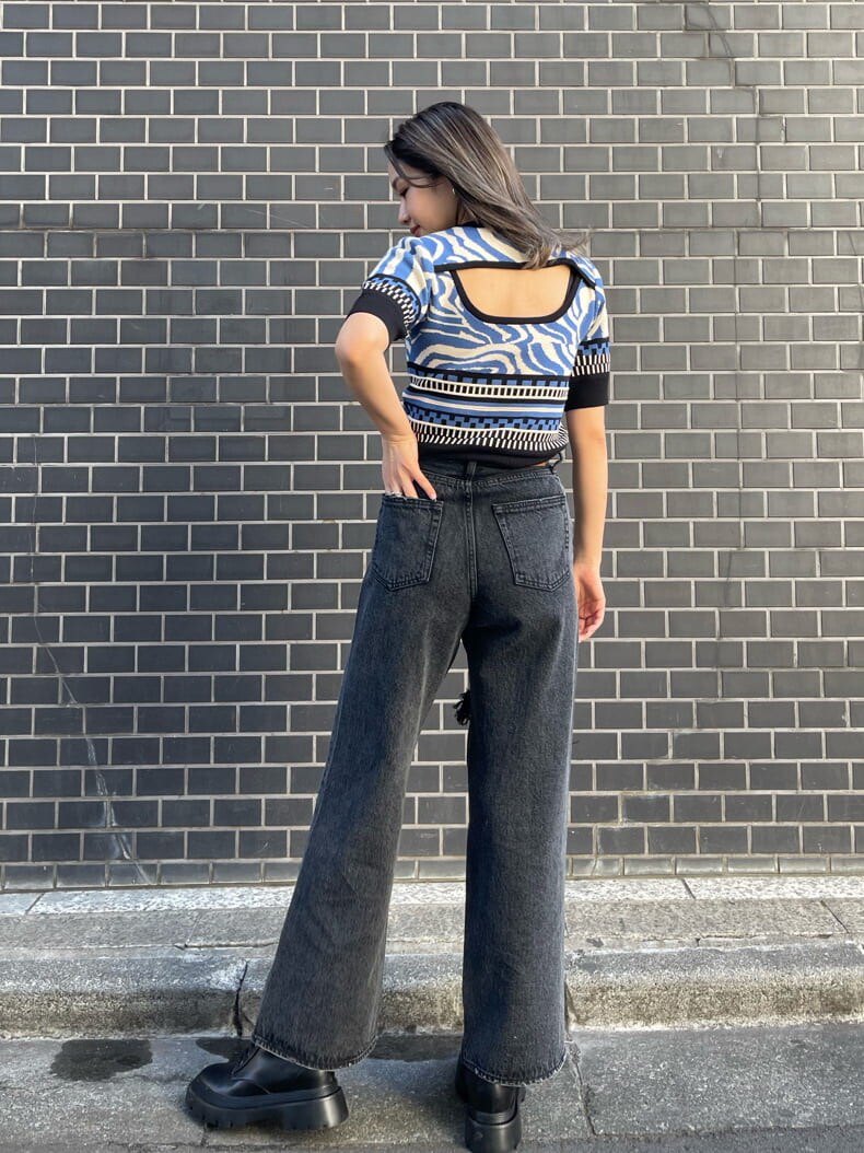 ブラック系のブーツ、ブラック系のデニムパンツ、ブルー系のニット/セーターを着用したレディースの春コーディネートの4枚目の写真