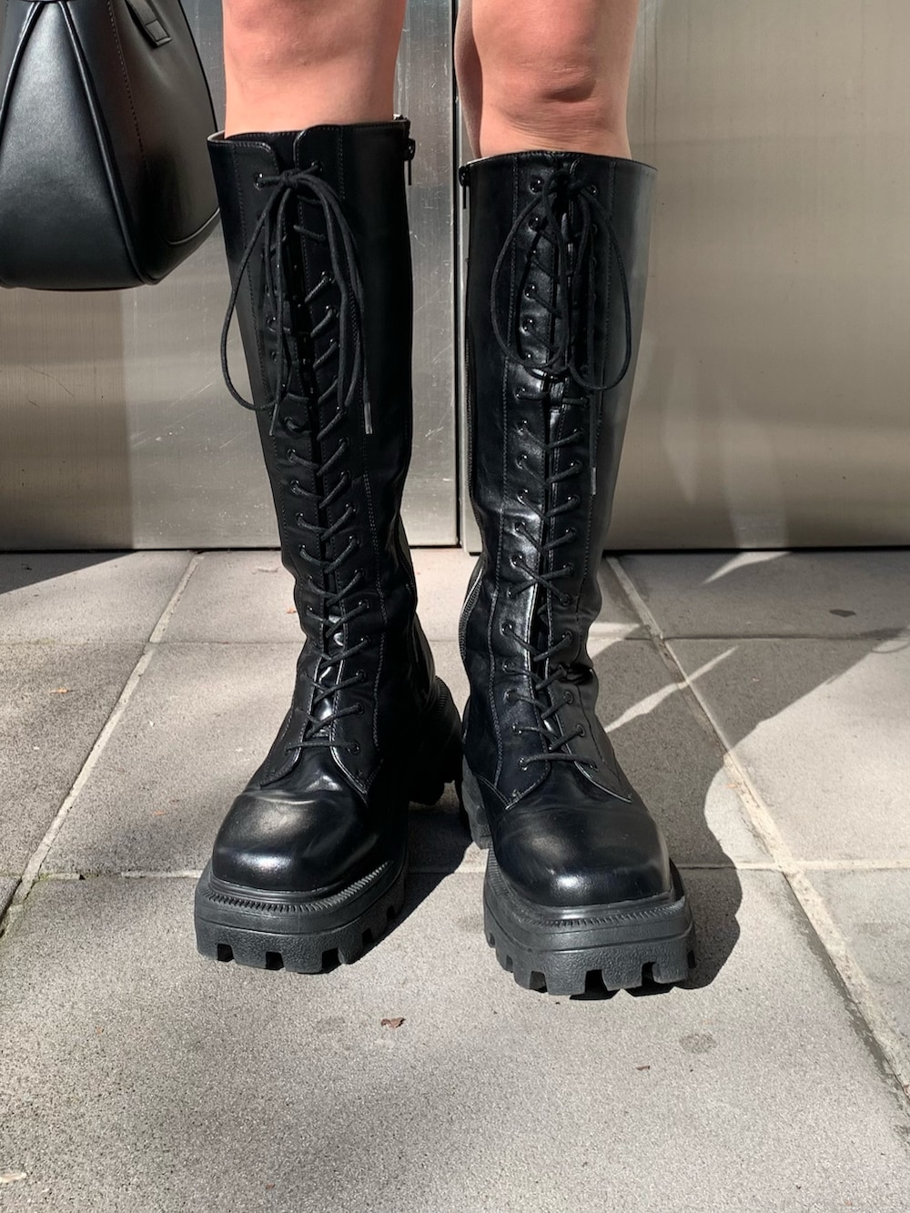 ブラック系のハンドバッグ、オレンジ系のカーディガン/ボレロ、ホワイト系のTシャツ/カットソーを着用したレディースの冬コーディネートの7枚目の写真