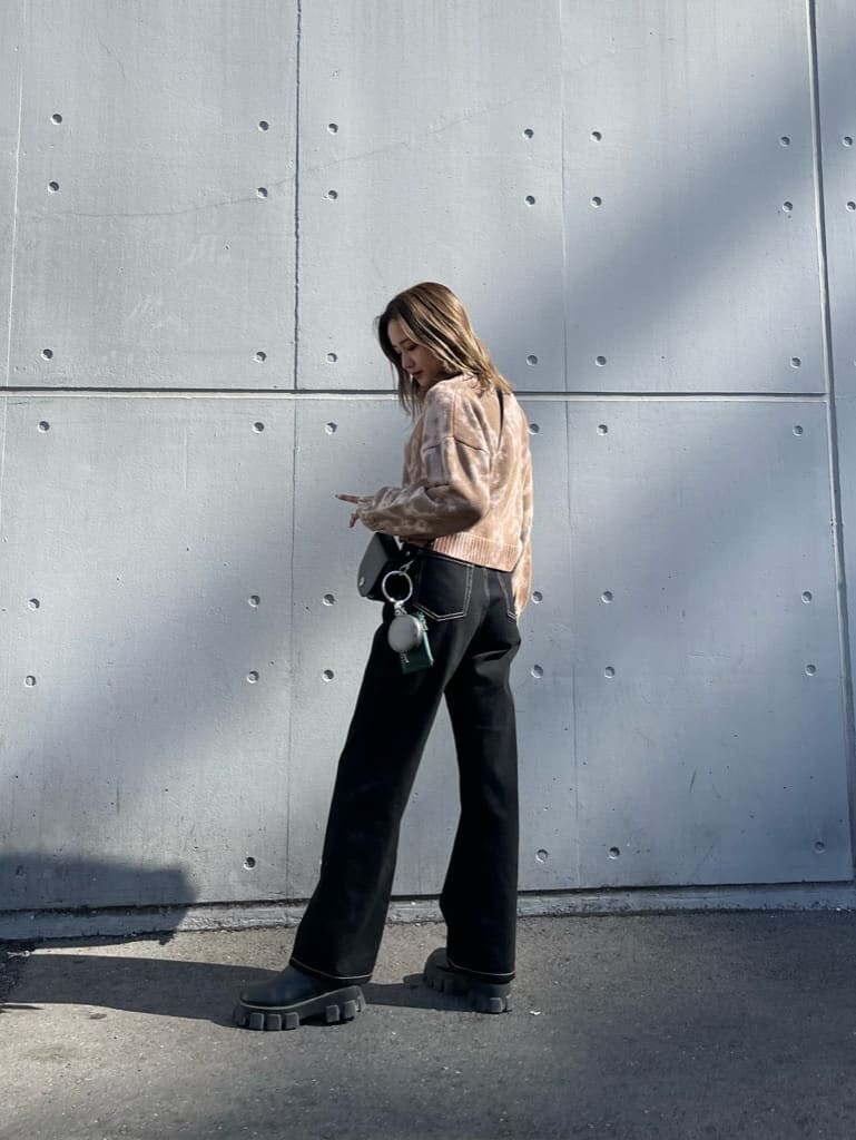 ブラック系のブーツ、ベージュ系のニット/セーター、ブラック系のデニムパンツを着用したレディースの秋コーディネートの2枚目の写真