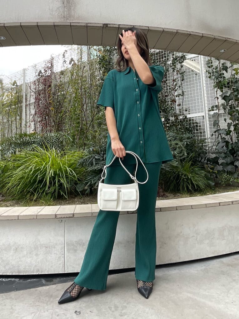 ブラック系のパンプス、ホワイト系のショルダーバッグ、グリーン系のその他パンツを着用したレディースの春コーディネートの2枚目の写真