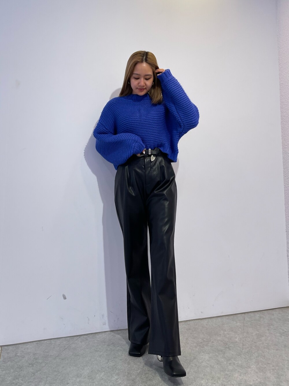 ブラック系のブーツ、ブルー系のニット/セーター、ブラック系のその他パンツを着用したレディースの冬コーディネートの2枚目の写真