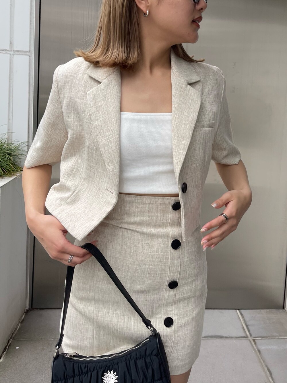 ブラック系のブーツ、ホワイト系のニット/セーター、ホワイト系のテーラードジャケットを着用したレディースの春コーディネートの5枚目の写真