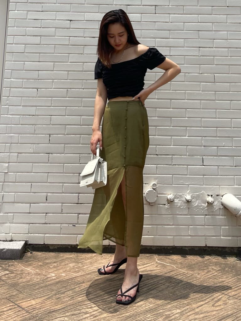 ベージュ系のスカート、ブラック系のサンダルを着用したレディースの夏コーディネートの2枚目の写真