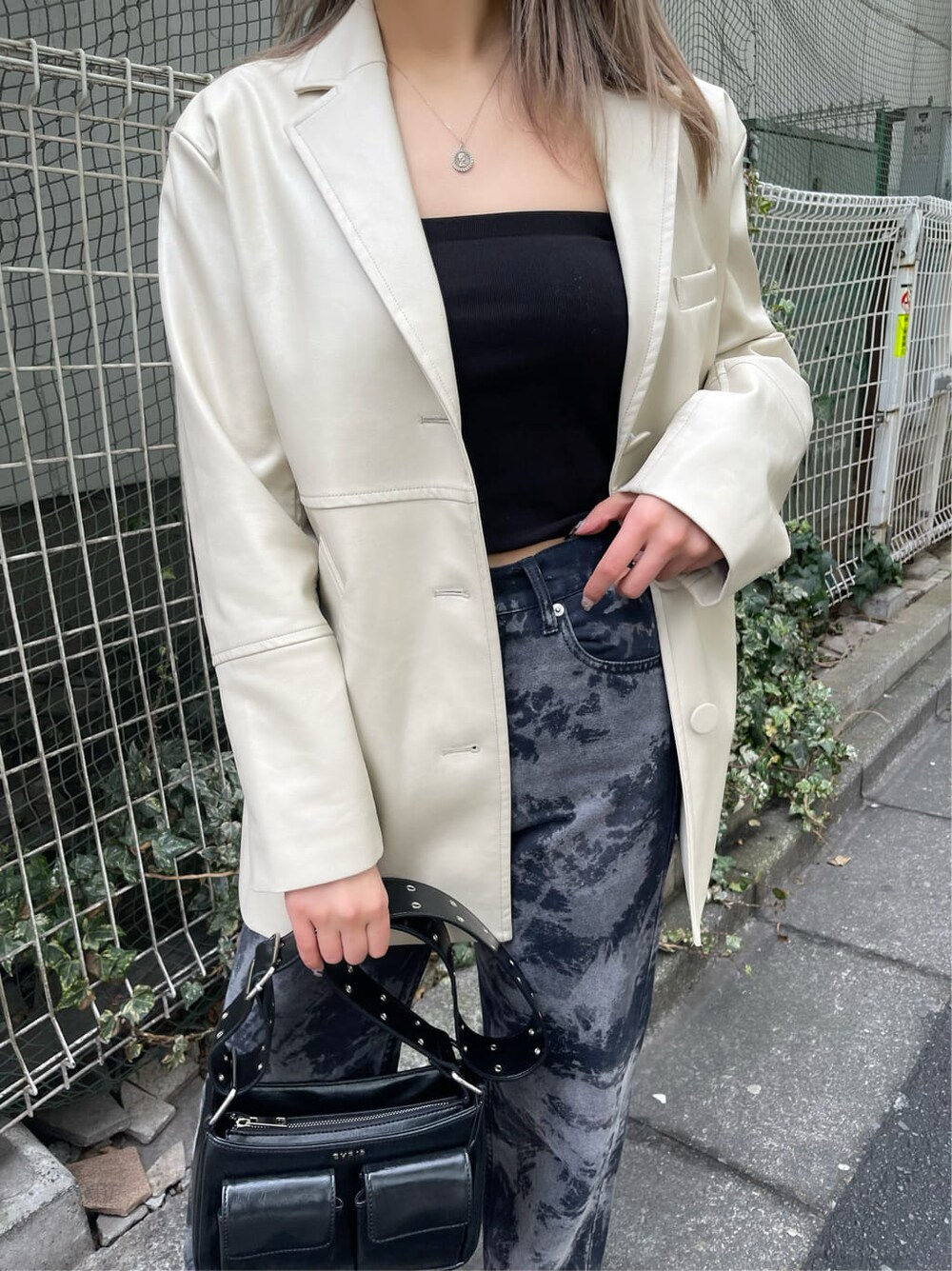 ブラック系のテーラードジャケット、ブラック系のショルダーバッグ、ブラック系のブーツを着用したレディースの冬コーディネートの6枚目の写真