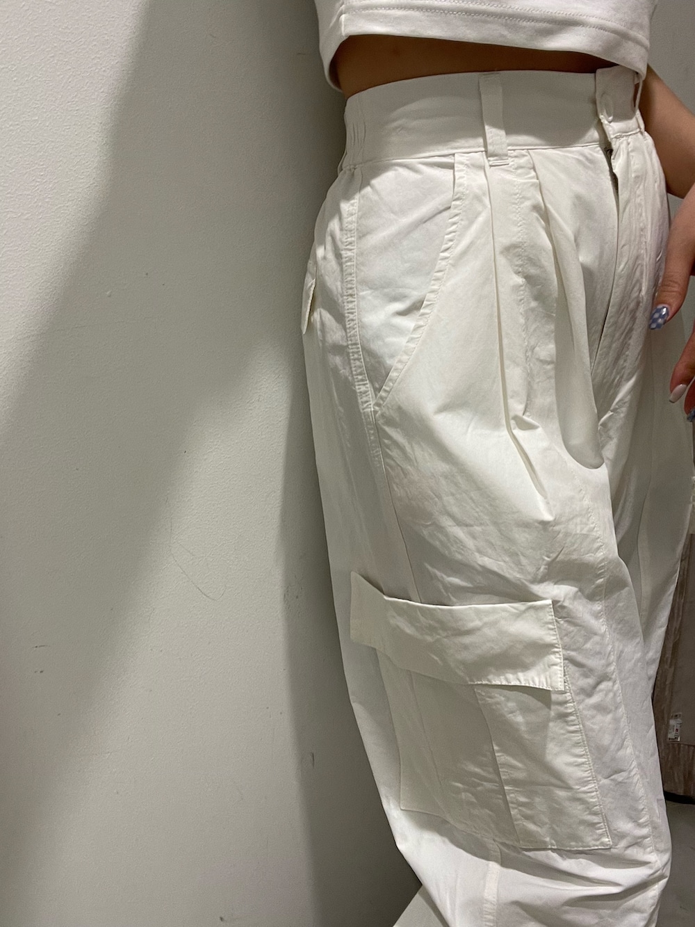 ホワイト系のカーゴパンツ、ブラック系のブーツ、ホワイト系のTシャツ/カットソーを着用したレディースの春コーディネートの8枚目の写真