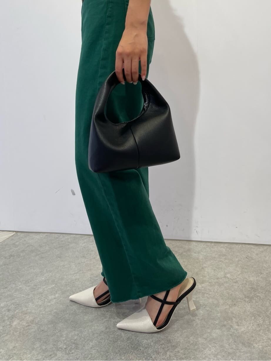 ブラック系のハンドバッグ、ホワイト系のサンダル、グリーン系のデニムパンツを着用したレディースの夏コーディネートの6枚目の写真