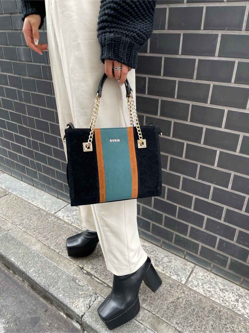 ブラック系のブーツ、ブラック系のニット/セーター、ブラック系のショルダーバッグを着用したレディースの冬コーディネートの7枚目の写真