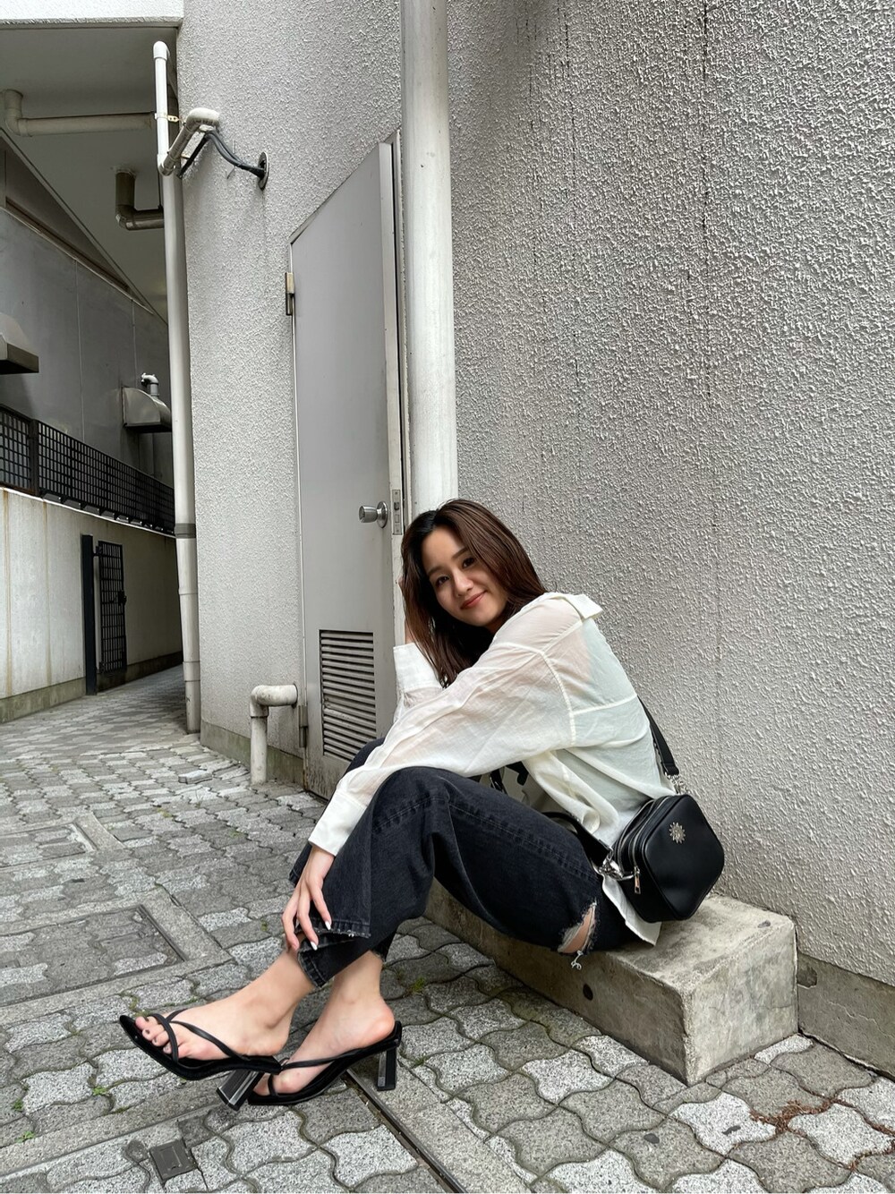 ブラック系のデニムパンツ、ホワイト系のシャツ/ブラウス、グリーン系のタンクトップを着用したレディースの春コーディネートの3枚目の写真