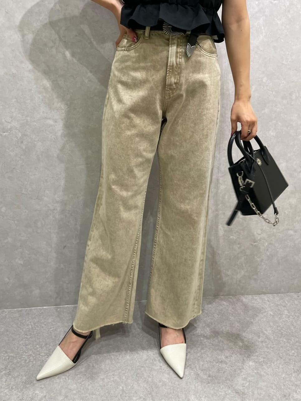 ブラック系のシャツ/ブラウス、ベージュ系のデニムパンツ、ホワイト系のサンダルを着用したレディースの春コーディネートの5枚目の写真