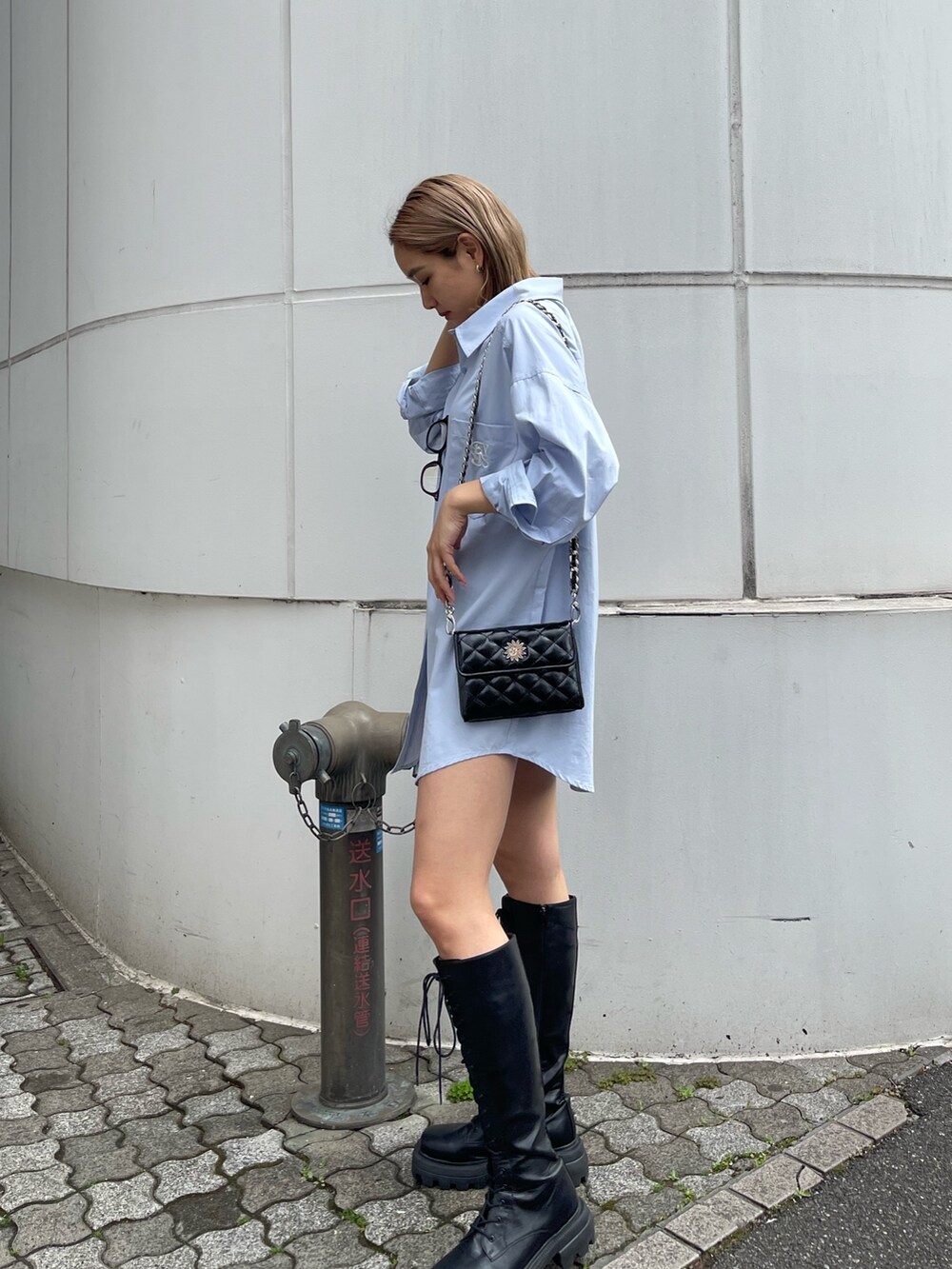 ブラック系のブーツ、ブラック系のショルダーバッグ、ブルー系のシャツ/ブラウスを着用したレディースの春コーディネートの3枚目の写真