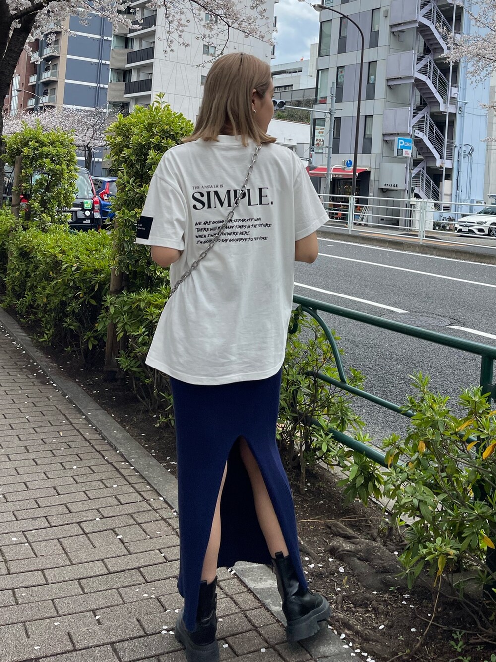 ブラック系のショルダーバッグ、ホワイト系のTシャツ/カットソー、ブルー系のスカートを着用したレディースの春コーディネートの4枚目の写真