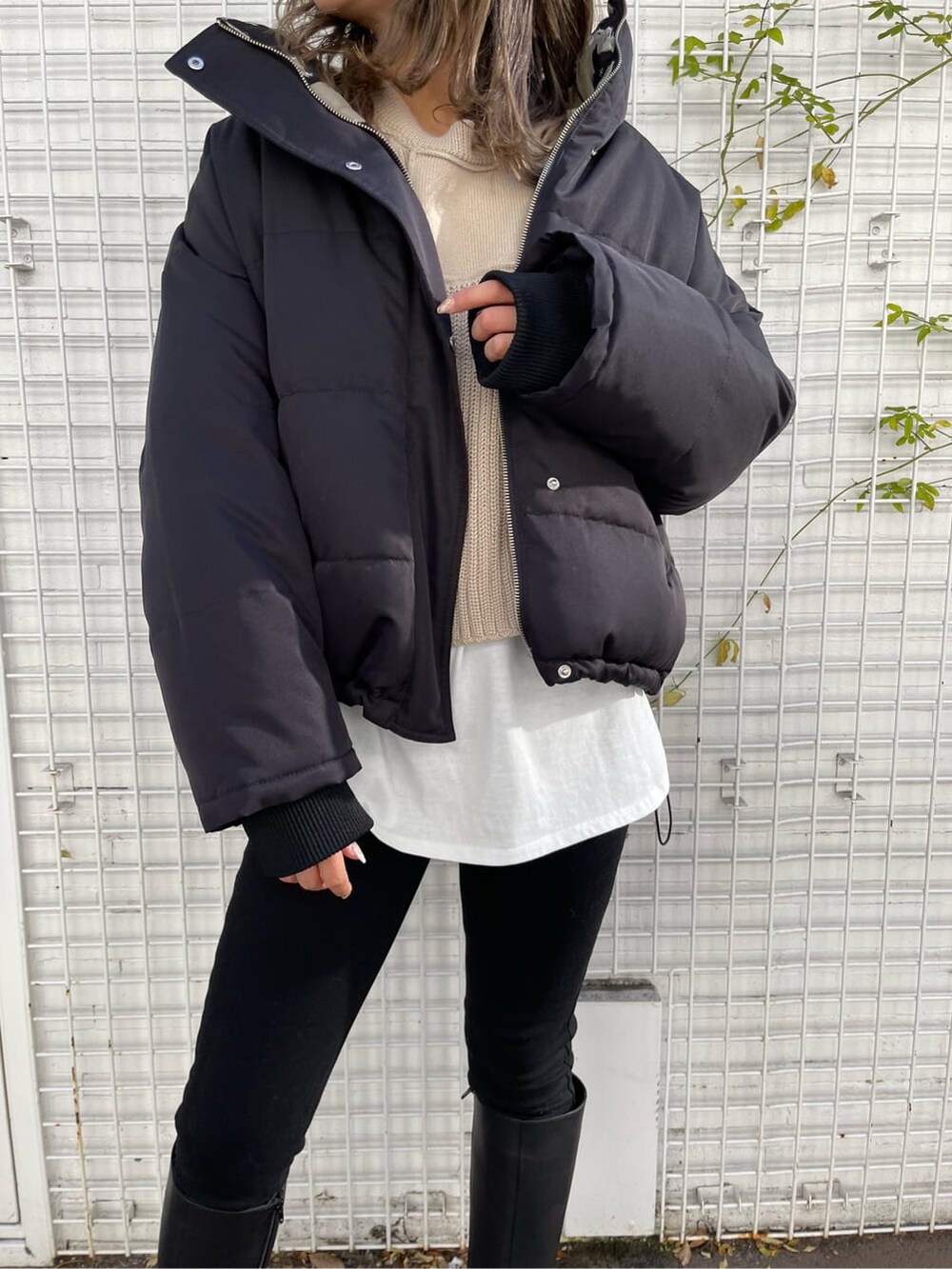 ブラック系のデニムパンツ、ブラック系のブーツ、ブラック系のダウンジャケット/コートを着用したレディースの冬コーディネートの4枚目の写真