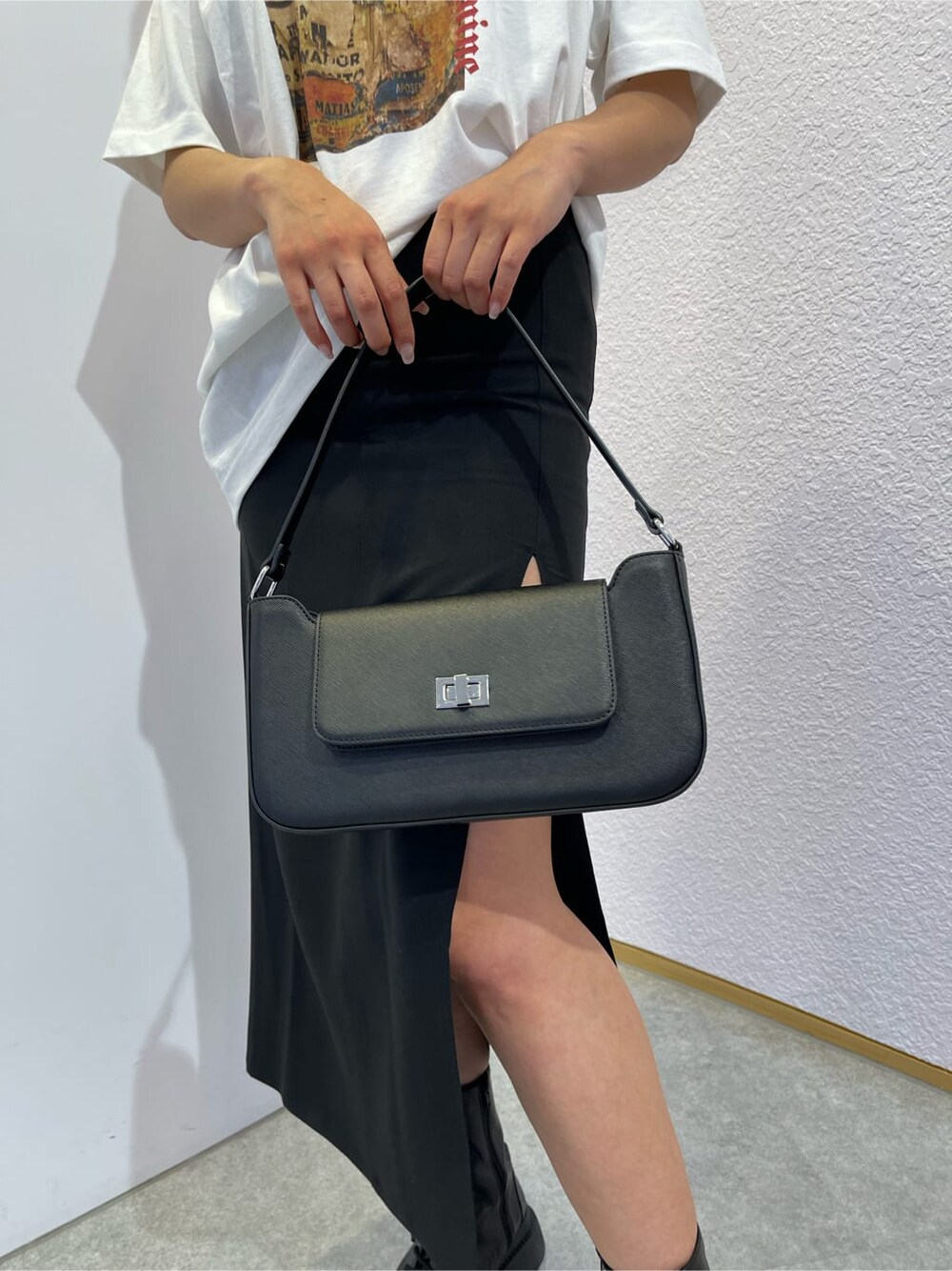 ブラック系のスカート、ブラック系のブーツ、ブラック系のショルダーバッグを着用したレディースの夏コーディネートの9枚目の写真