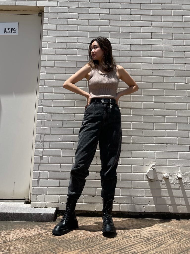 ブラック系のブーツ、ブラック系のデニムパンツ、ベージュ系のニット/セーターを着用したレディースの夏コーディネートの2枚目の写真